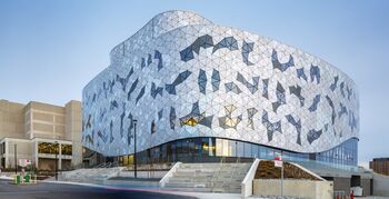 Golvende gevel van Bergeron Centre reflecteert licht en wolken